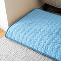 Tapis rafraîchissant bleu pour chien posé sur un tapis de salon